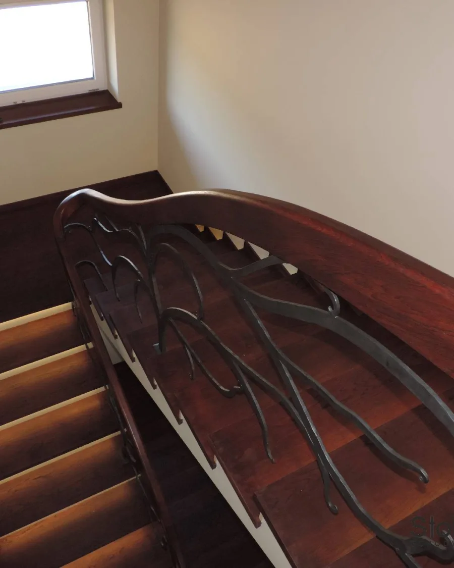 Widok z góry na dębowe schody z kutą balustradą i okno dachowe w klatce schodowej — Dynów