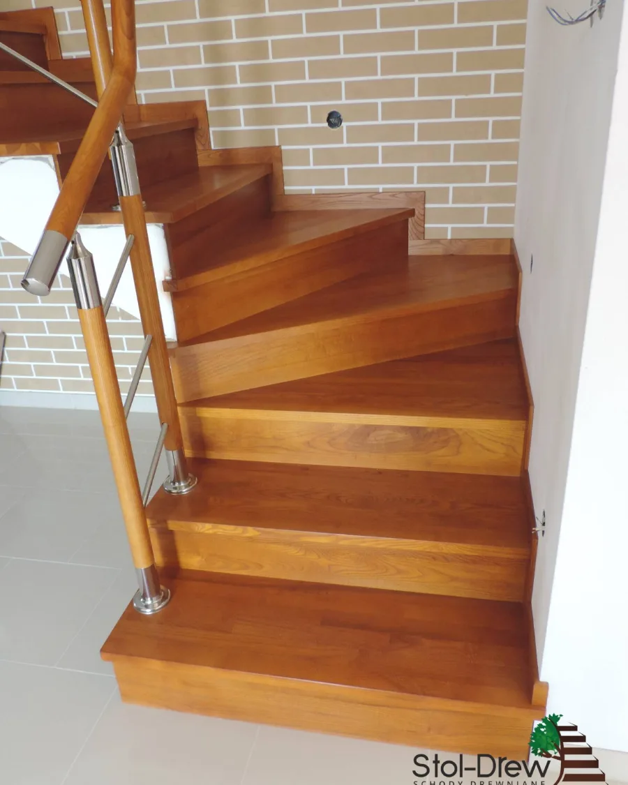 Pierwsze stopnie z zabiegiem i słupki z drewnianą okładziną przy balustradzie z rurek, widok z boku — Krosno
