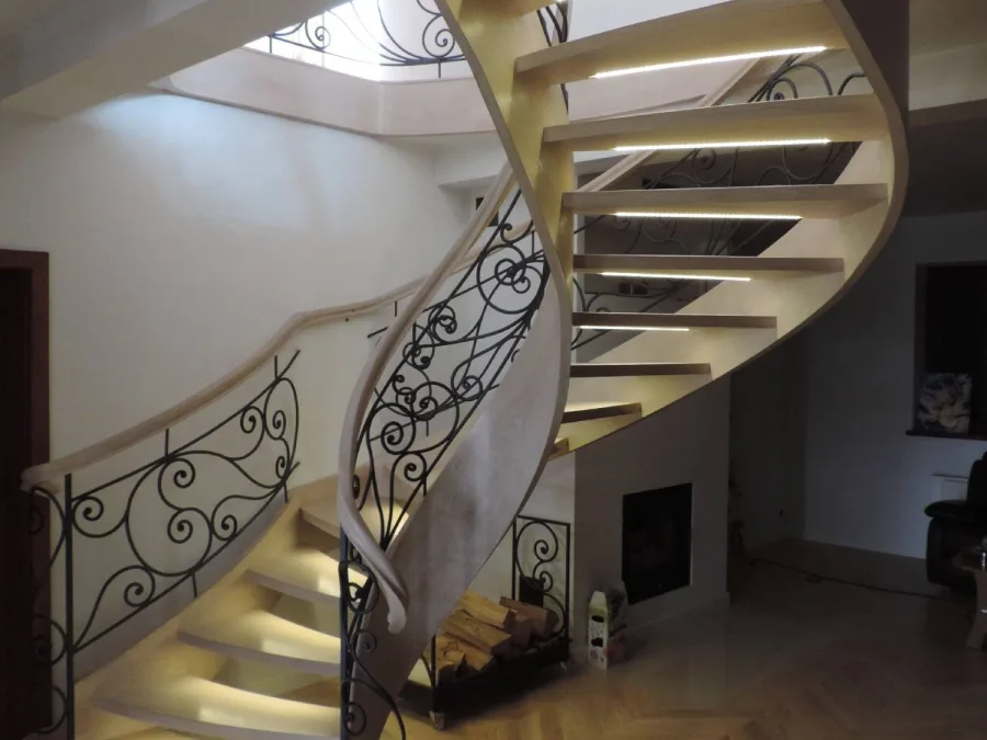 Kręte schody wieczorem z kutą balustradą z ornamentem