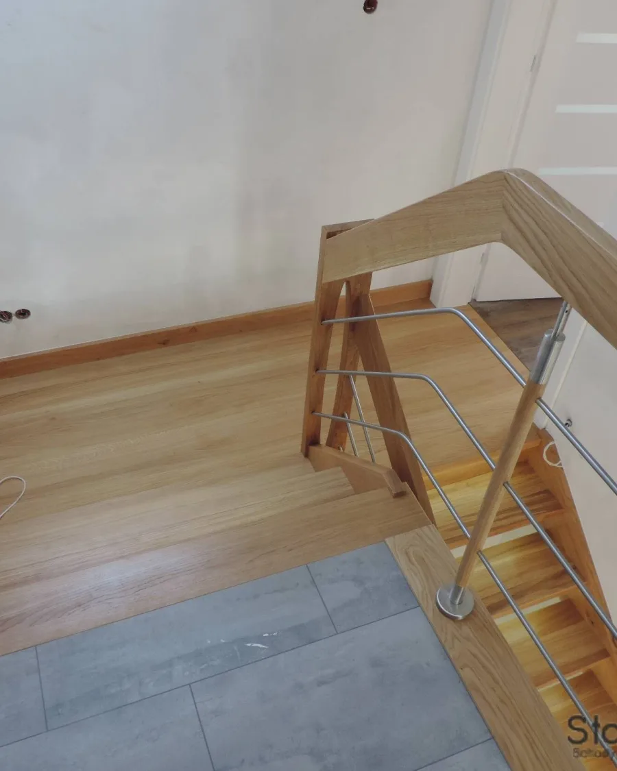 Dębowy narożnik balustrady z rurkami ze stali nierdzewnej przy wyjściu schodów na piętro — Rzeszów