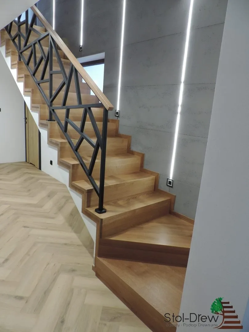 Dębowe schody na beton typu dywanowego z czarną balustradą ze stalowych profili, widok od dołu — Zagórz