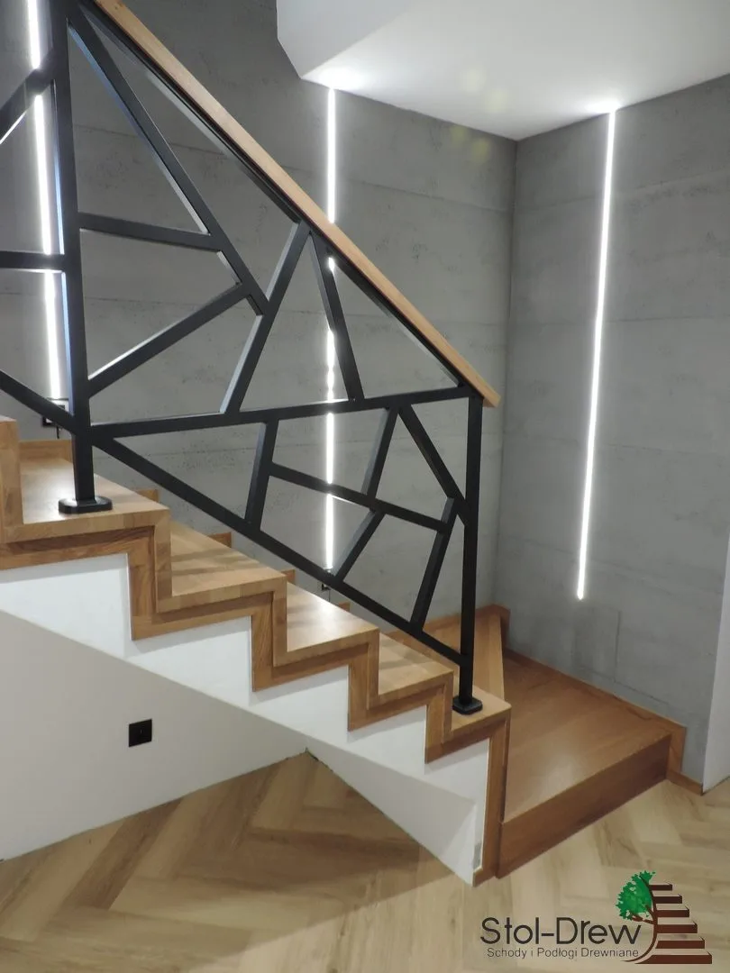 Zbliżenie na geometryczną czarną balustradę i dębowy pochwyt wzdłuż zębatego boku schodów — Zagórz