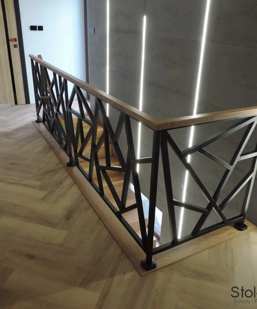 Krótki odcinek stalowej balustrady z drewnianym pochwytem przy wejściu na piętro — Zagórz